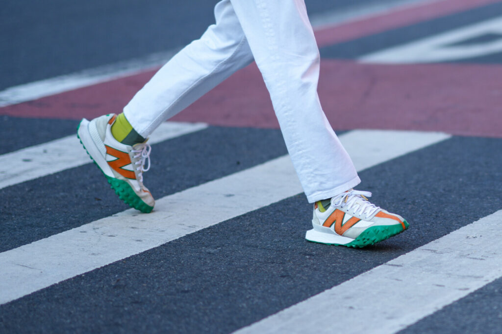sneakers New Balance bianche con logo arancione e suola verde e bianca