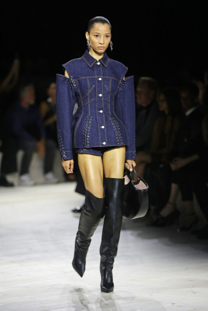 Moda scarpe primavera estate 2024 – modella in completo di jeans e stivali alti neri, Alexander McQueen